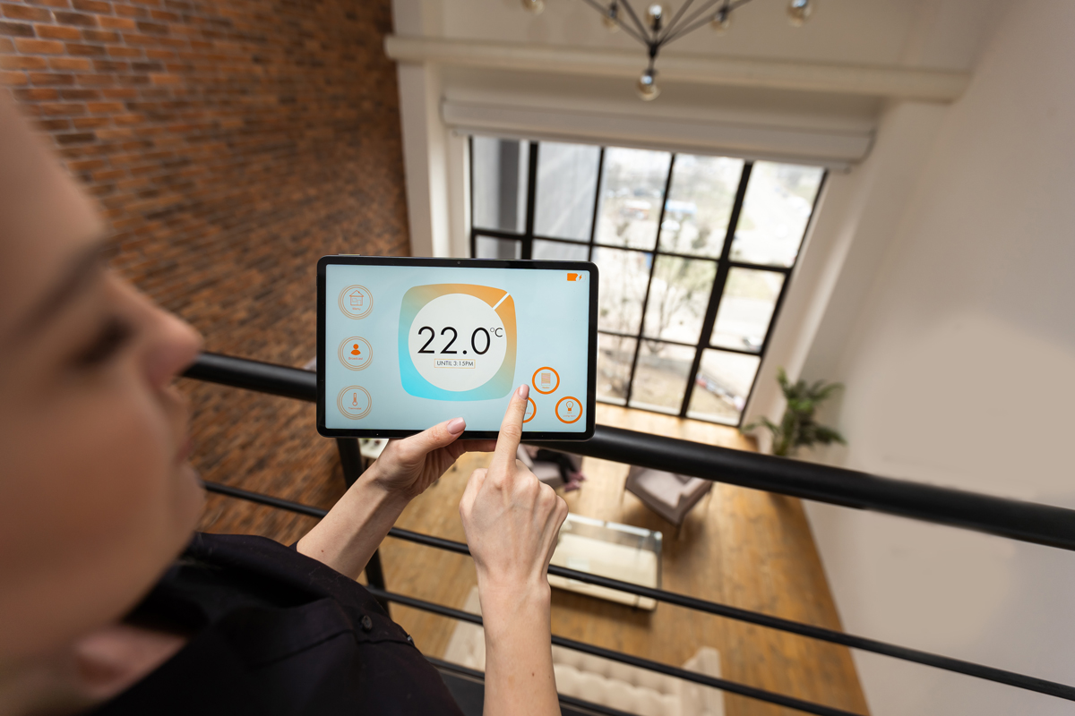 Female hands holding digital tablet with smart home app smart thermostat zones