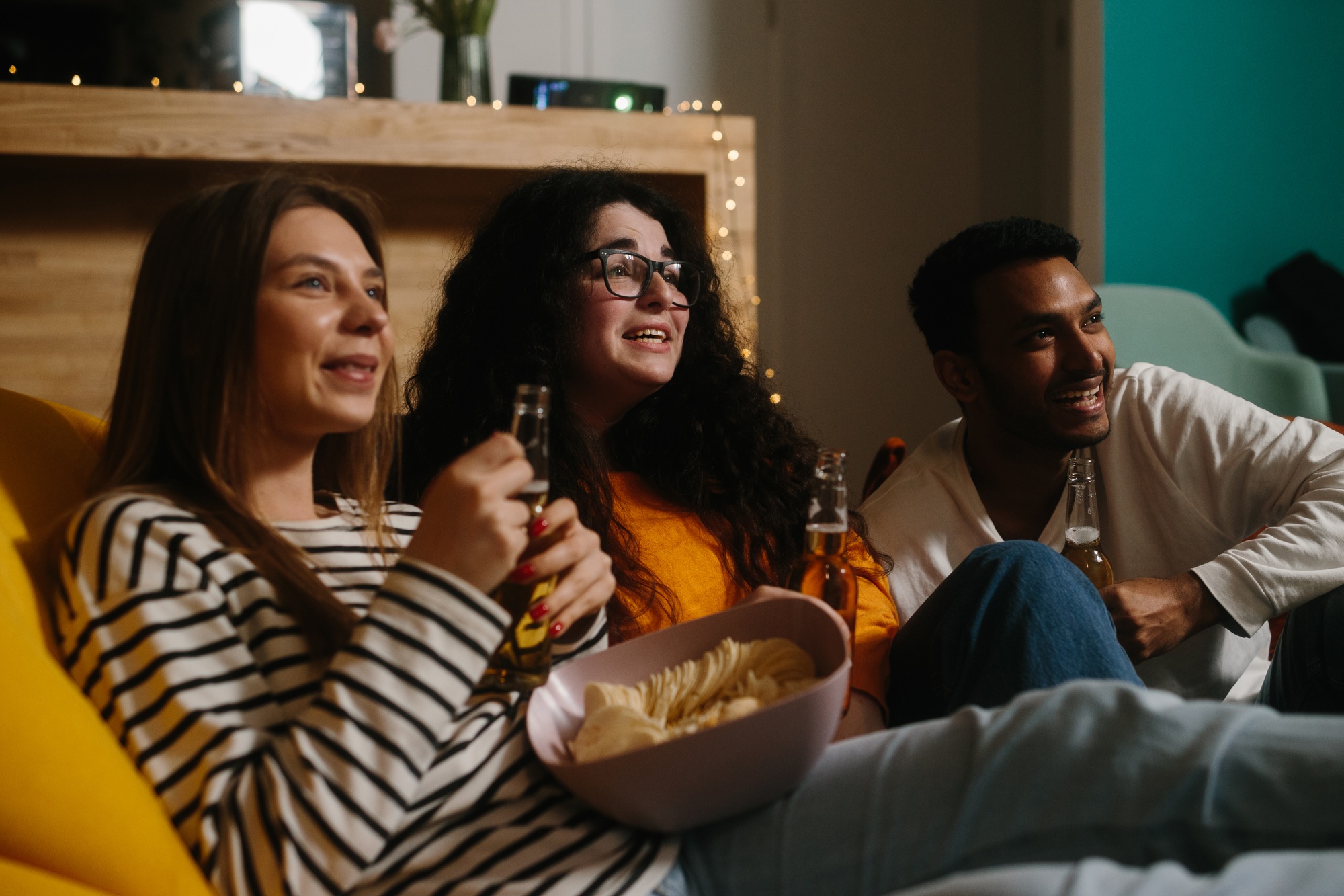 Group of people in the home theater with chips and drinks.