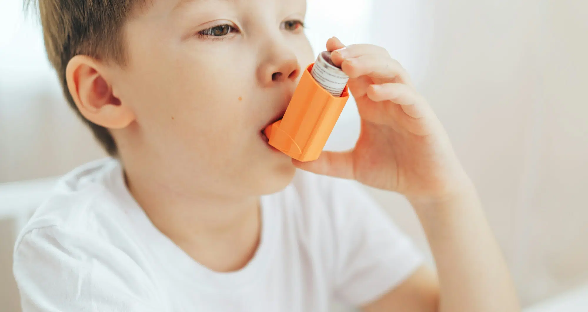 Little Boy Inhales Medicine Through An Asthma Inhaler