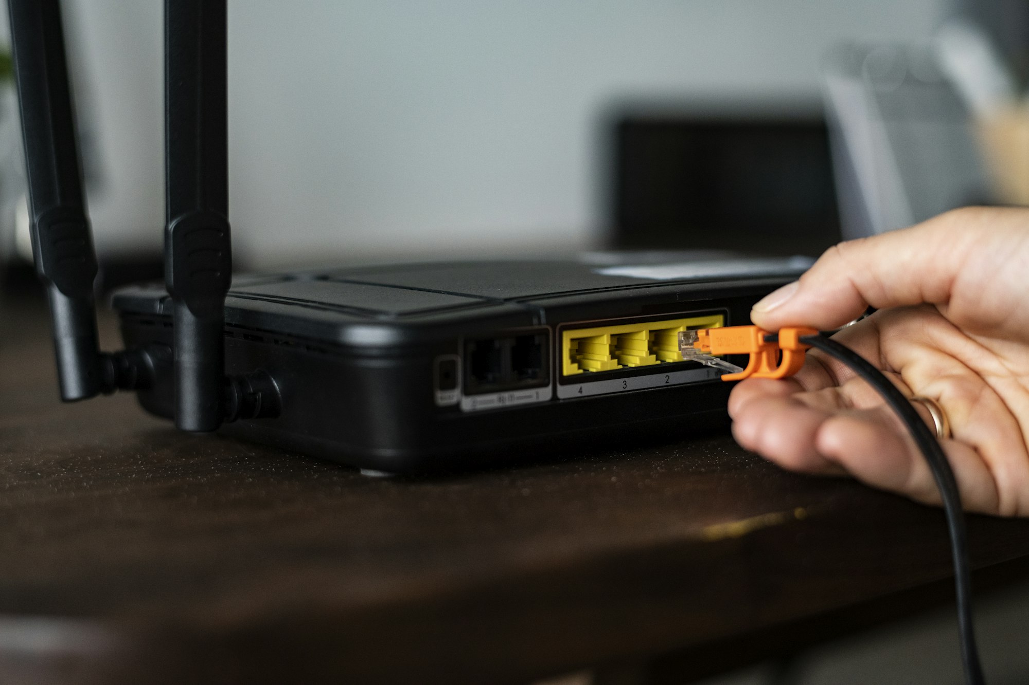 Man plugging in an Ethernet cable to a wireless router