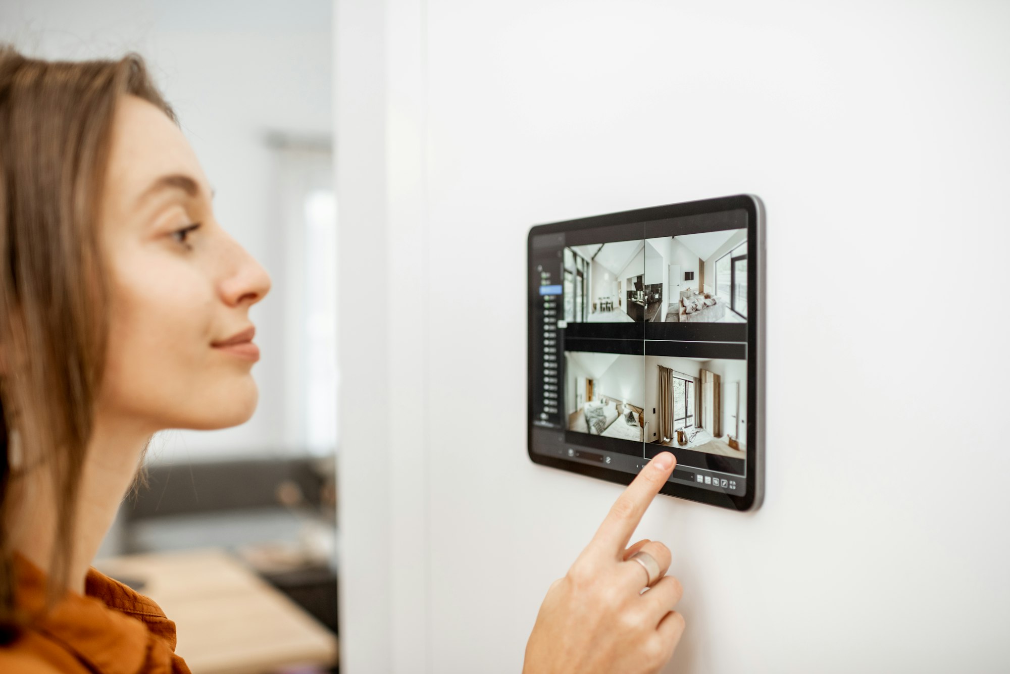 Woman controlling home with video cameras and digital tablet