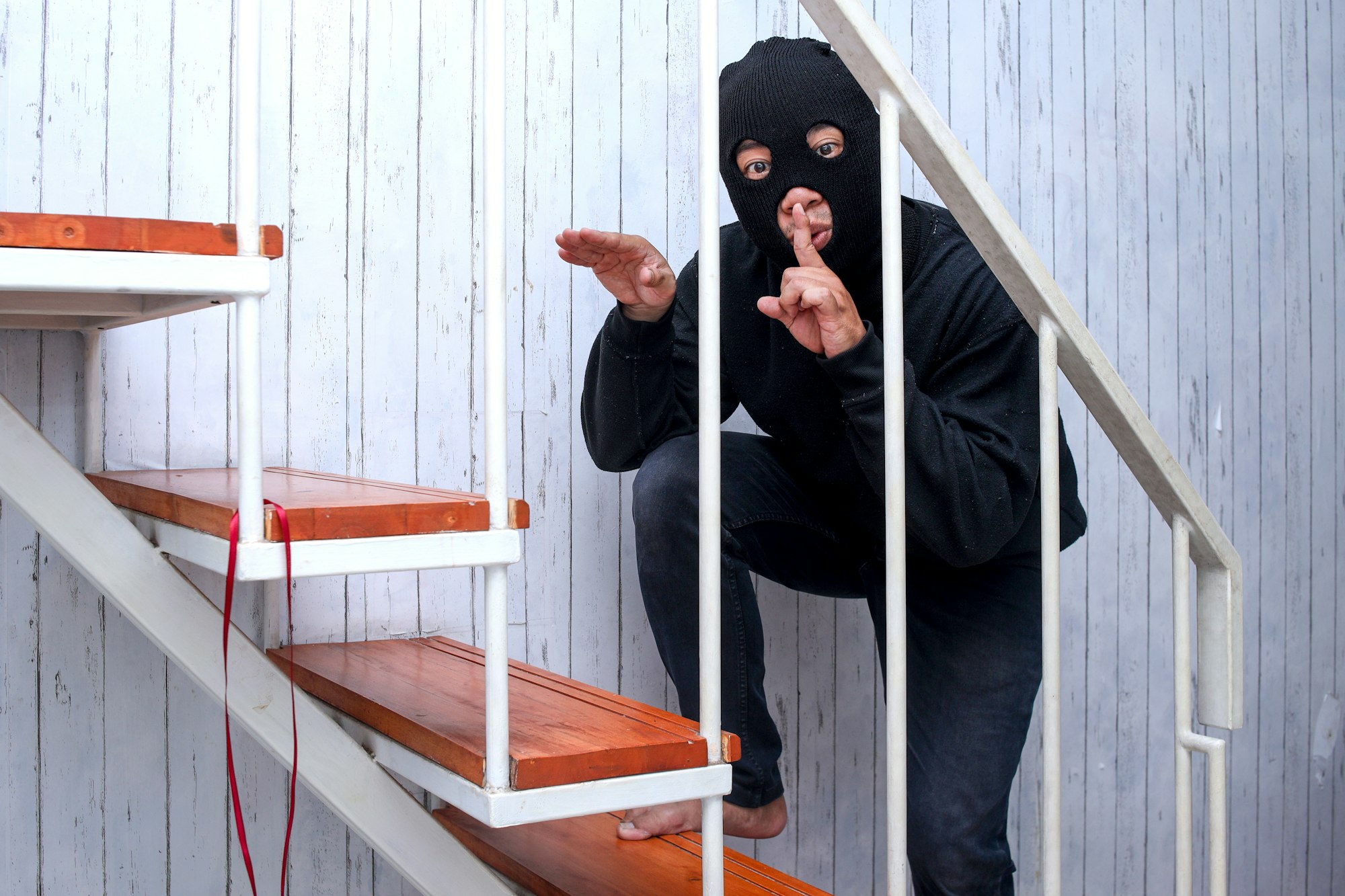 Masked Thief or House Intruder Standing on Staircase Making Hush Sign Guide to Smart Home Security