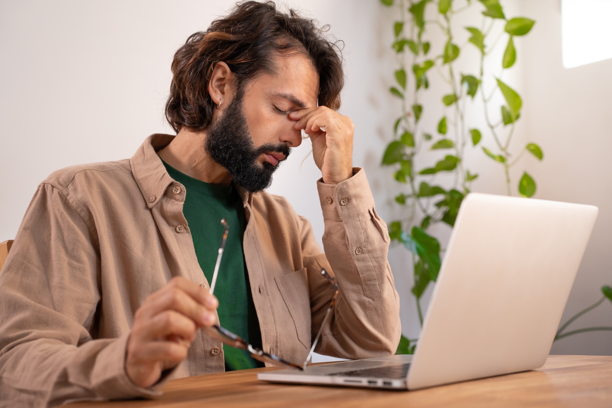 Stressed tired businessman suffering from headache in front of computer.