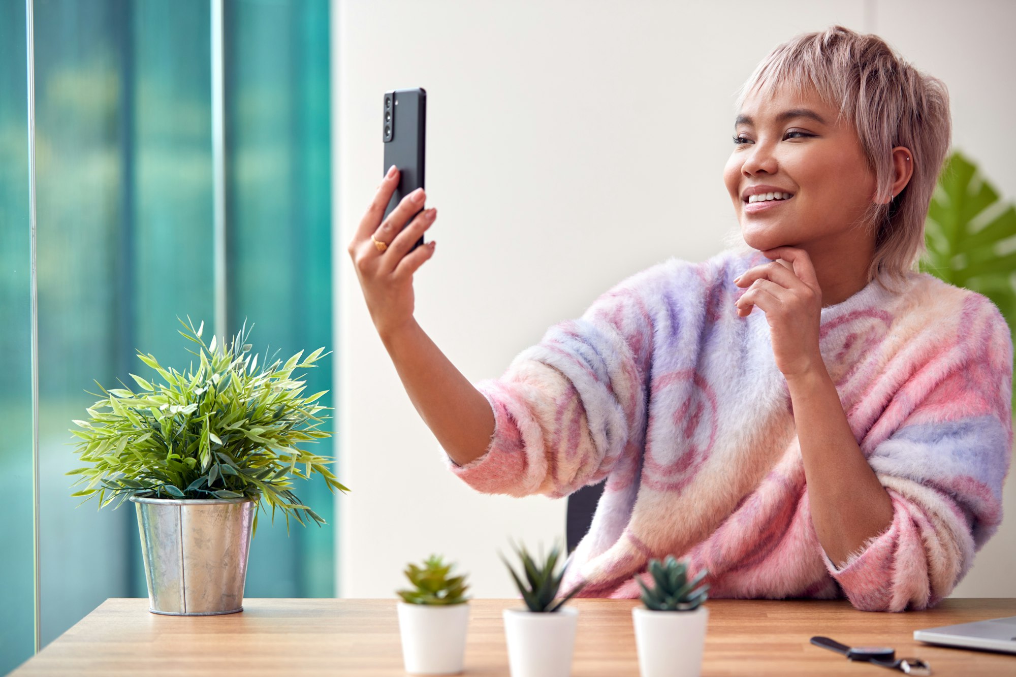 Woman At Home Taking Selfie On Mobile Phone To Post On Social Media